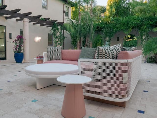 An outdoor living space with a large sitting area and a white round table in the middle