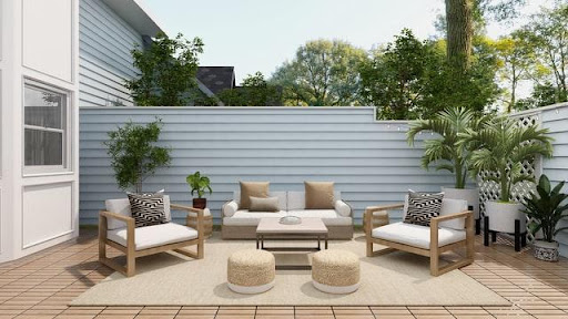 An outdoor living space behind a white house with a brown tile floor and several seating places