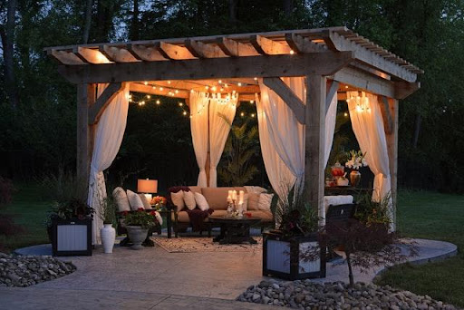 A gazebo with curtains and string lights as an example of how to create a functional outdoor living space