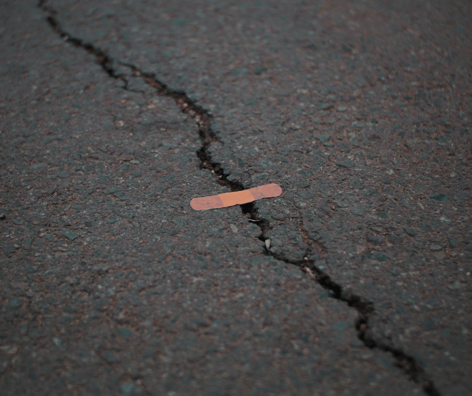A band-aid patching up an asphalt crack