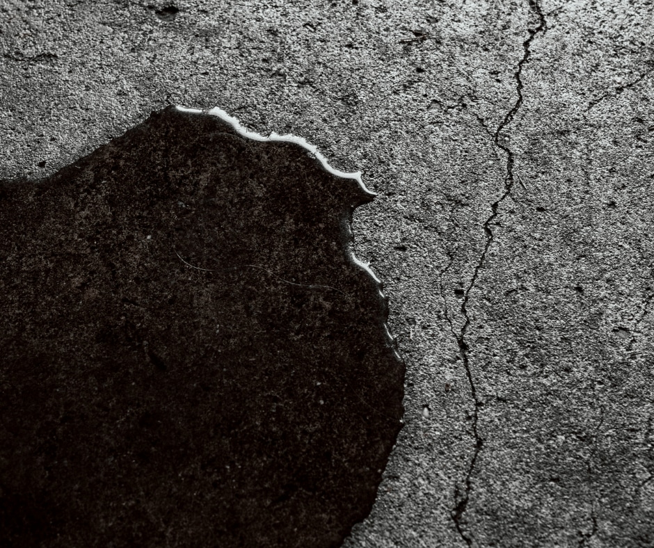 Liquid approaching a crack on the floor – one of the signs it's time to replace your driveway